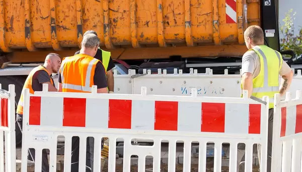 Vier Straßenbauarbeiter auf einer Baustelle