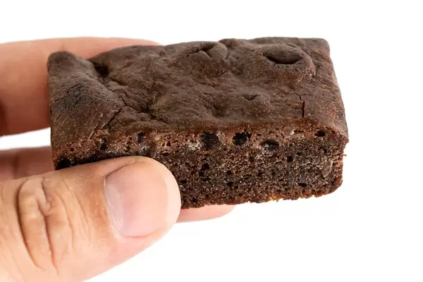 Viereckiger Schokoladenmuffin in einer Hand