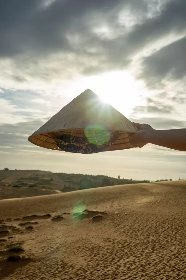 Vietnamese Hat in front of the Sunset in the Red Sand Dunes in Mui Ne