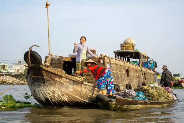 Vietnamese Women selling Fresh Fruits and other Goods from their Boats at Cai Rang Floating Market in Can Tho, Vietnam