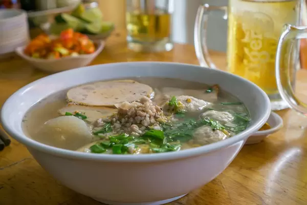 Vietnamesische Nudelsuppe mit Pilzen und Kräutern aus Schweinebrühe in Saigon