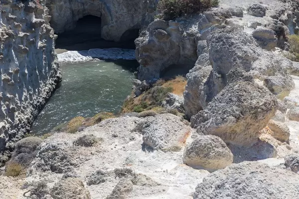 View from above: small inlet formed by the waters between steep rock faces near Pachena, Milos