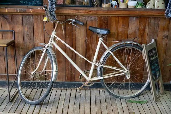 Vintage Bicycle next to a Wooden Stool and a Wooden Stand in front of a Cafe in Da Lat, Vietnam