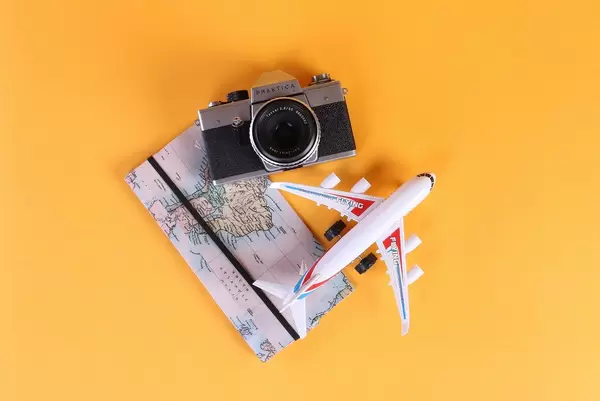 Vintage camera, map and airplane on orange background