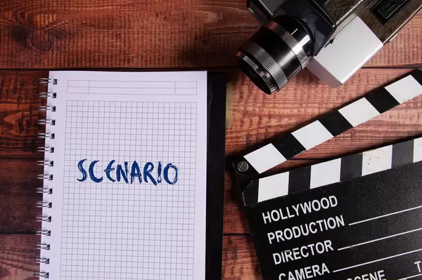 Vintage camera, movie clapper and notebook withScenario text