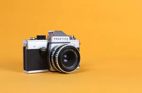 Vintage camera on orange background