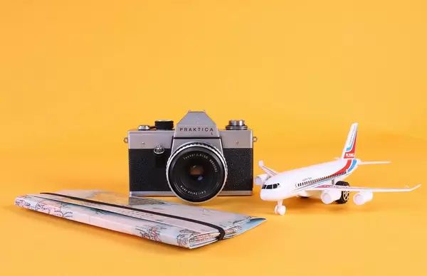 Vintage camera with map and airplane on orange background