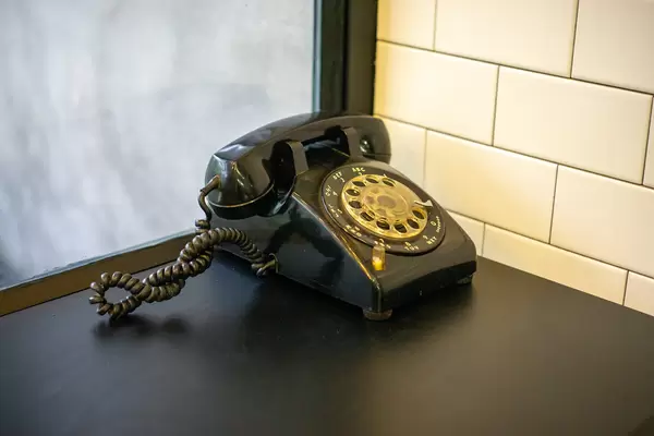 Vintage Rotary Dial Telephone on a Wooden Table as Decoration inside a Cafe