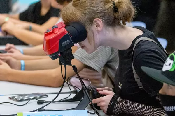 Virtual-Reality-Headset: Mädchen spielt Videospiele mit der Handheld-Konsole Virtual Boy von Nintendo