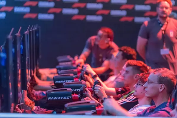 Visitors playing F1 2018 with racing wheel controllers by Fanatec