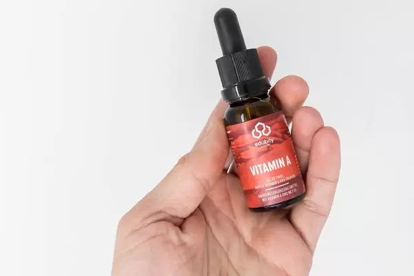 Vitamin A Tropfen von Edubily in der Hand vor weißem Hintergrund. Vitamin A schützt das Immunsystem