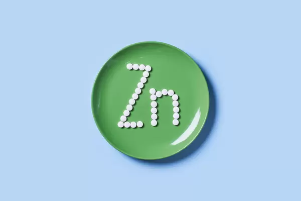 Vitamin Zink symbol on green table