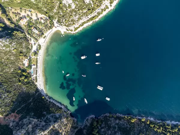 Vogelperspektive: Die Bucht von Limnonari mit Kiefern, Booten und Sandstrand auf Skopelos