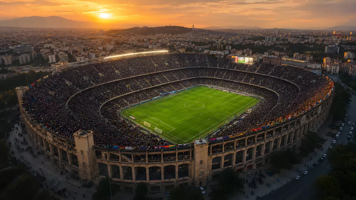 Vollbesetztes Fußballstadion bei goldenem Sonnenuntergang