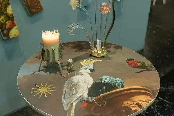 Von Künstler gestalteter runder Beistelltisch mit detailreichem Vogelmotiv, dekoriert mit Kerze