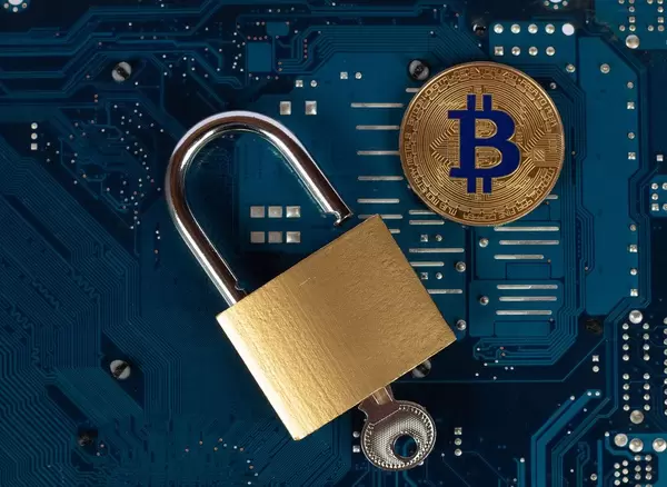 Vorhängeschloss mit Bitcoin auf Computerteilen