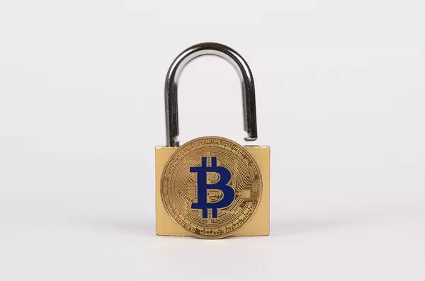 Vorhängeschloss mit goldenem Bitcoin vor weißem Hintergrund