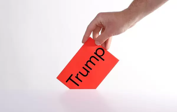 Voter holds red envelope in a hand with Trump text