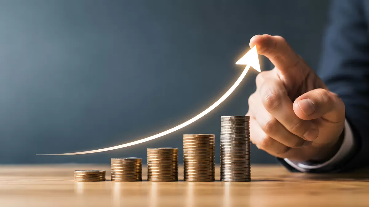 Wachsende Münzstapel mit aufsteigendem Pfeil als Finanzsymbol