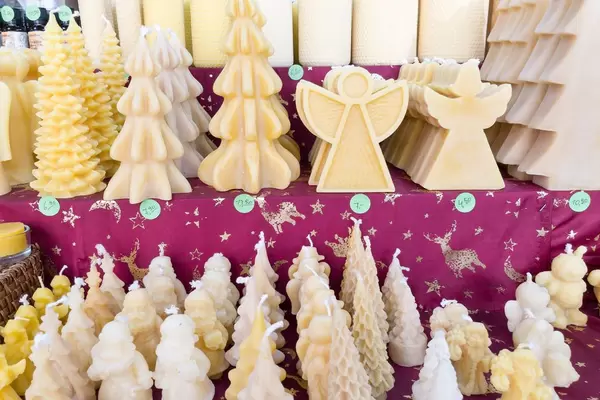Wachskerzen in Form von Weihnachtsbäumen und Engeln