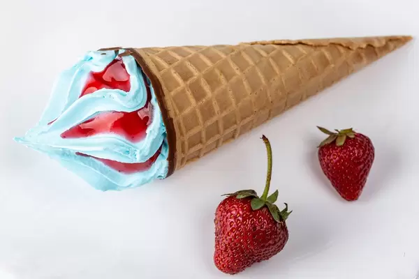 Waffle cone with blue ice cream and strawberries