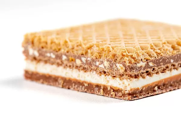 Waffle with chocolate and nuts on a white background close-up (Flip 2020)