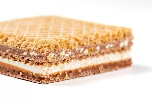 Waffle with chocolate and nuts on a white background close-up