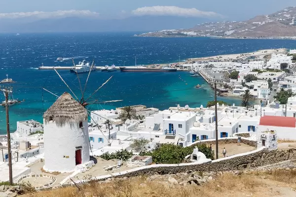 Wahrzeichen der Kykladen: Windmühle auf Mykonos mit Blick auf die Stadt und den Hafen von Chora