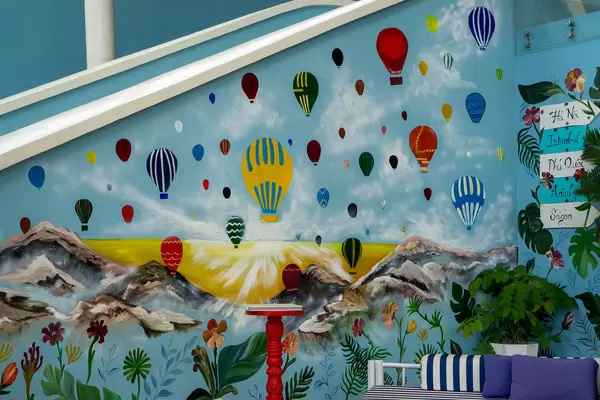 Wall Art with Colorful Hot Air Balloons, Mountains, Sunset and Plants on a Staircase Wall at Istanbul Beach Club in Phu Quoc, Vietnam