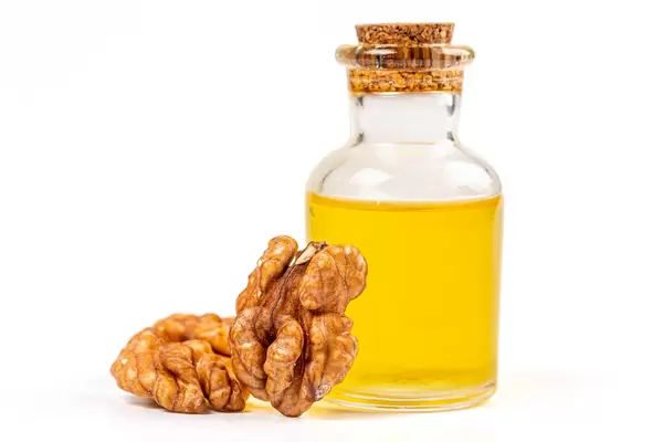Walnut essential oil and fresh, unshelled walnuts