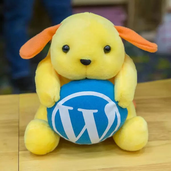 Wapuu plush toy with blue Wordpress logo at the BarCamp Bonn