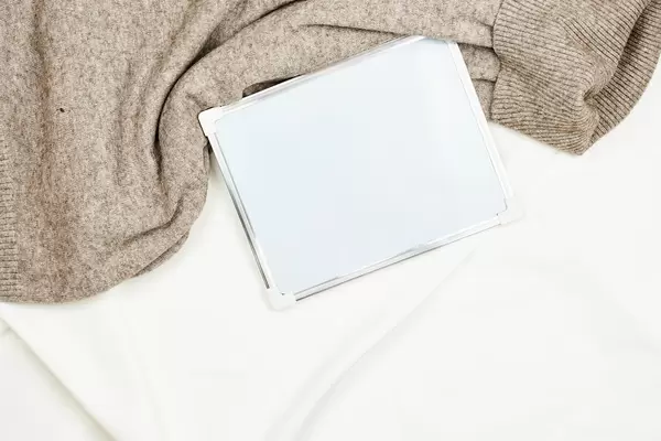 Warm sweater and whiteboard with copy space