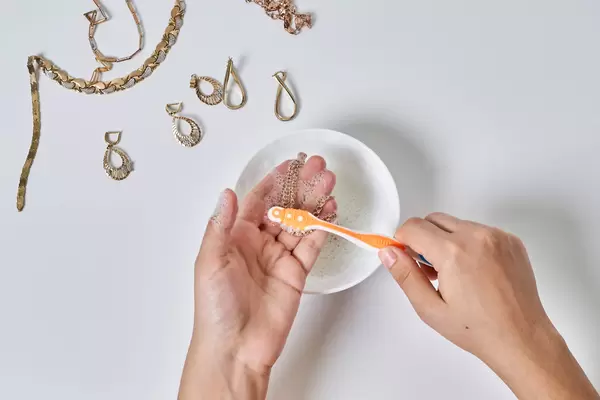 Washing golden jewelries with brush and soap