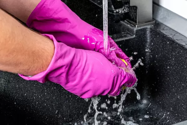 Washing the kitchen napkin under the tap with water in the kitchen