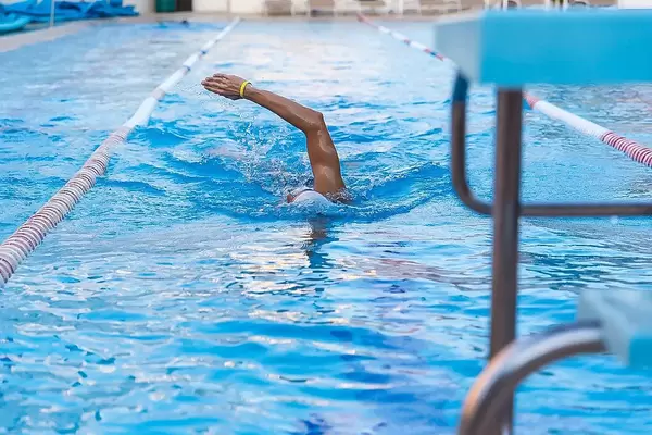 Wassersportler beim Kraulschwimmen auf der abgetrennten Bahn