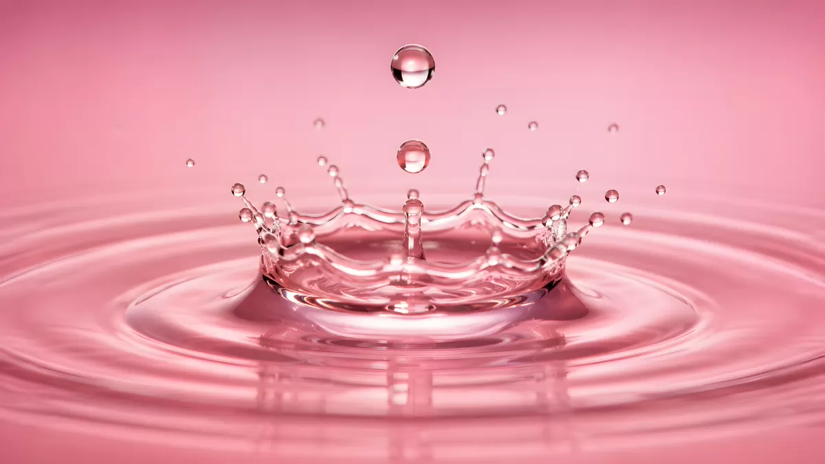 Wassertropfen trifft Oberfläche – rosa Spritzeffekt