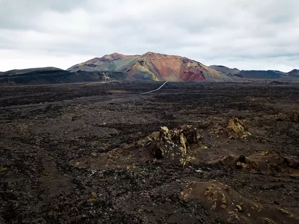 Wasteland landscape with colorful mountain at horizon / Ödlandlandschaft mit buntem Berg am Horizont