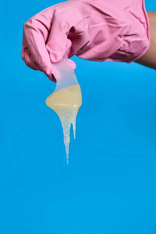 Wax for depilation. Close-up of epilation liquid against blue background