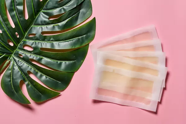 Wax strips with honey on bright pink background