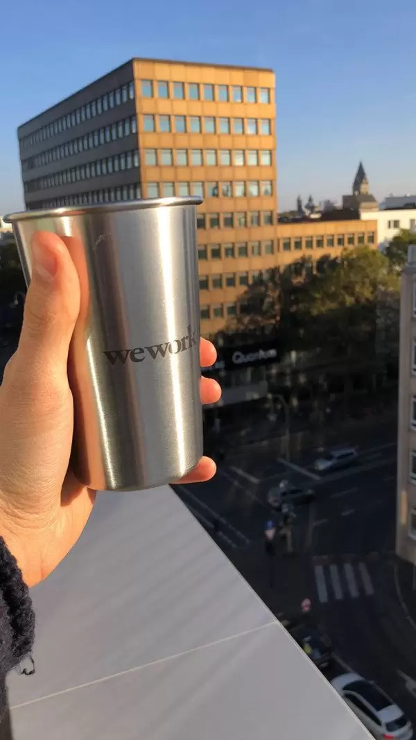 We Work Coworking space - silberner Kaffeebecher mit wework aufschrift