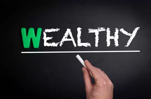 Wealthy text on blackboard