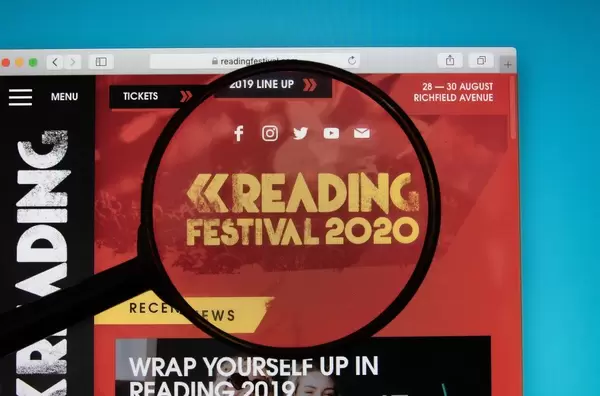 Website des Reading Festivals auf PC-Bildschirm, Lupe hebt das Logo hervor
