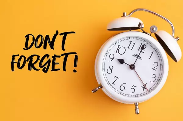 Wecker mit dem Text ‘Don’t forget!’ vor gelbem Hintergrund