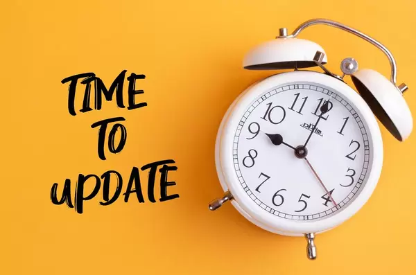 Wecker mit dem Text ‘Time to update’ vor gelbem Hintergrund