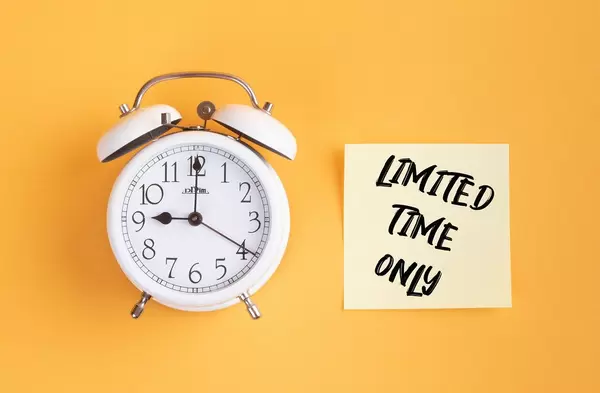 Wecker und ein Zettel mit ‘Limited time only’ Text vor gelbem Hintergrund