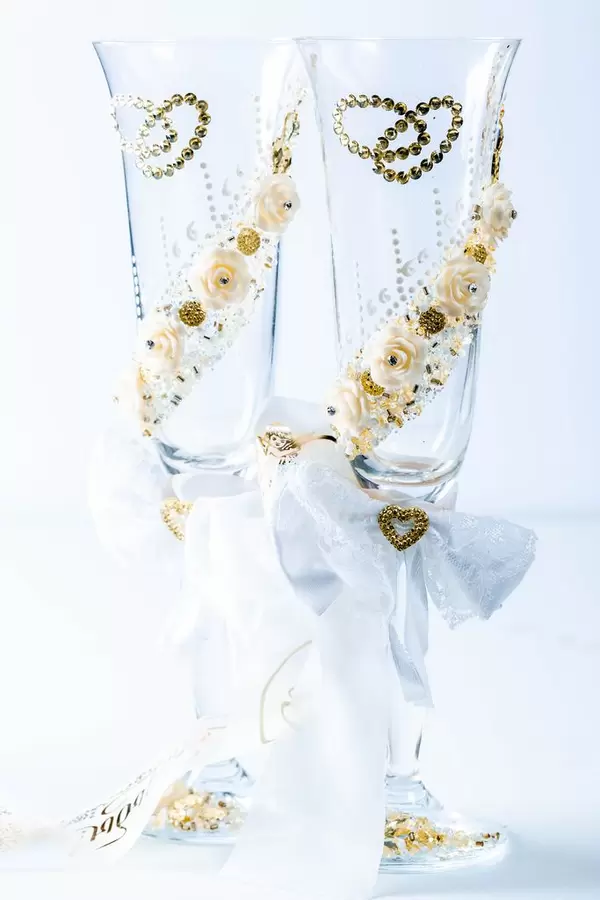 Wedding glasses and wedding decor with ribbon on white background