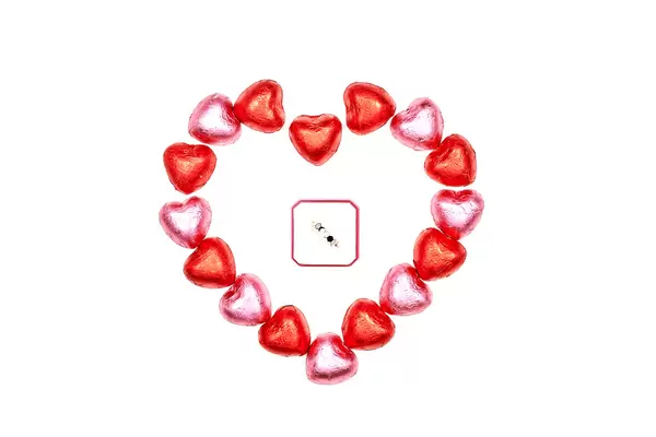 Wedding ring in the box with sweet candies around