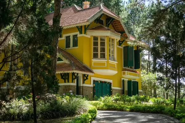Weg zu einer alten Französischen Villa im Park der Bao Dai Residenz mit vielen Pflanzen und Blumen in Da Lat, Vietnam