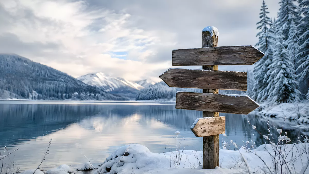Wegweiser am verschneiten Bergsee im Winter