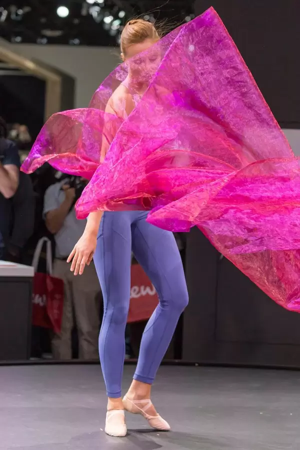 Weibliche Tänzerin mit pinkem Tuch umhüllt an der Photokina in Köln